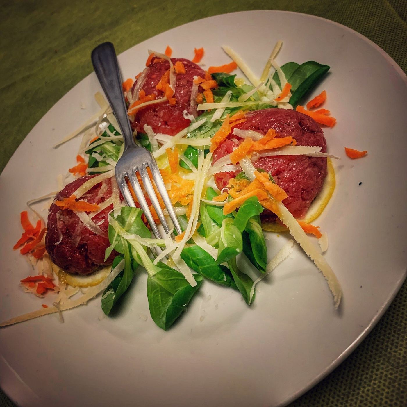 Carne cruda battuta con insalata, carote e scaglie di formaggio